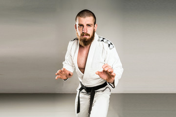 Black Belt in Fighting Stance wearing white Gi BJJ judo kimono