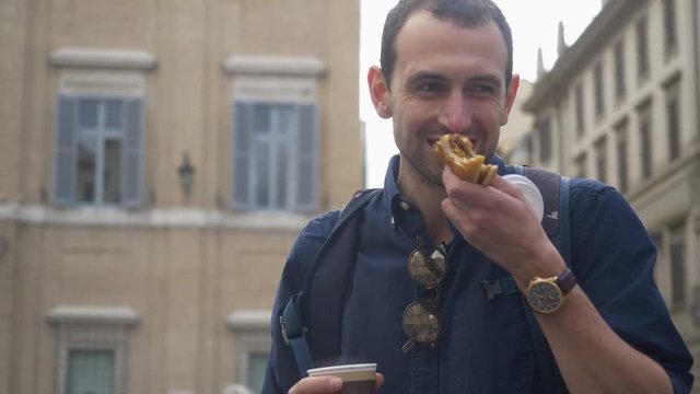 Young Man Smiling And Enjoying Lunch On The Go While Exploring A New City.