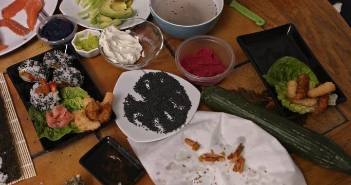 Close up of a woman preparing homemade sushi, the Japanese delicacy. Shrimp and salmon are also being prepared.