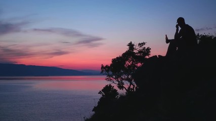 Sunset in Croatia. A man drinking beer and enjoying the view.