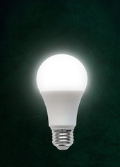 Illuminated LED Light Bulb on Chalkboard Background