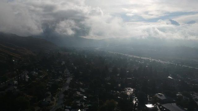 Drone footage of the San Fernando valley at the 210 freeway at Osbourne. Drone is flying through the clouds/fog. View of the 210 freeway.