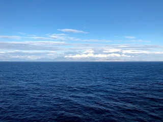 Obraz premium Horizon in the Andriatic blue sea and beautiful white clouds. A look at the horizon in the open sea. Cropped shot, horizontal, empty space, concept of leisure and travel