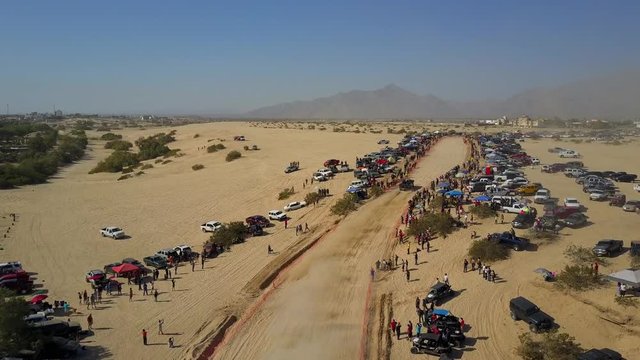 Aerial shot of the San Felipe 250 race. Trophy Truck comes from behind the camera and into frame driving with the camera movement.