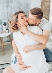 Beautiful pregnant woman and her husband is in their bedroom