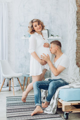 Beautiful pregnant woman and her husband is in their bedroom