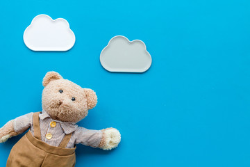 Handmade toys for newborn baby. Teddy bear. Blue background top view mockup