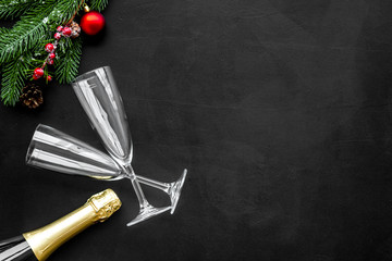 new year design with spruce, champagne bottle and glasses black table background top view space for text