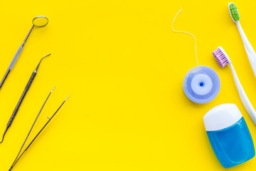 Daily oral hygiene for family. Toothbrush, dental floss and dentist instruments on yellow background top view mock up