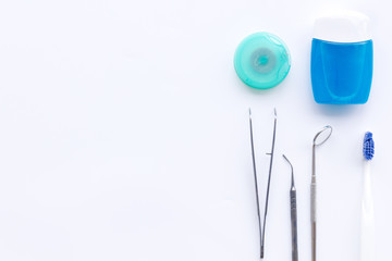 Daily oral hygiene for family. Toothbrush, dental floss and dentist instruments on white background top view space for text