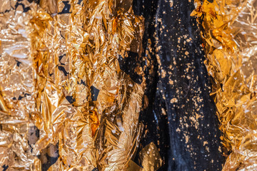 Gold leaf or Gold foil texture of buddhism on The Buddha statue in temple at thailand