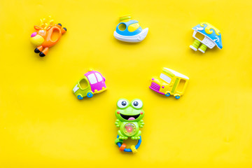 Craft toys for kids. Developing rattle for the smallest and baby bottle with milk. Yellow background top view mock up