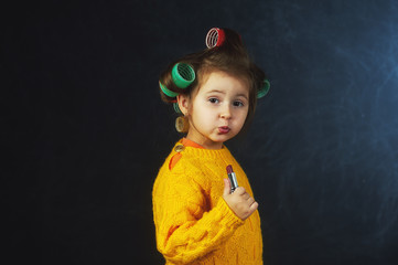 Portrait of a little fashionable girl in curlers .The concept of femininity