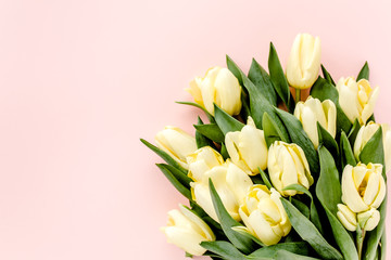 Pastel and yellow tulip flowers bouquet on pink background. Flat lay, top view. Valentine's background. Minimal floral concept.
