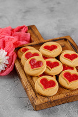 Obraz na płótnie Canvas Cookies with a heart-shaped filling in on a wooden board. Concept for Valentine's Day.