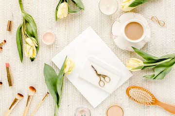 Plakat Female workspace with yellow tulip flowers, women's golden accessories, diary, glasses on white background. Flat lay. Top view feminine background.