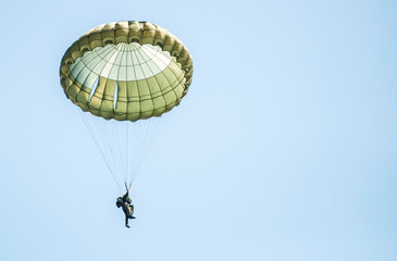 Many soldiers with parachutes in the sky.
