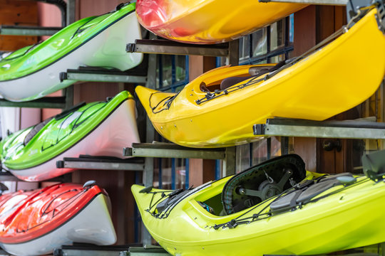 Brightly colored kayaks for rental stacked outside a water sports shop in Vancouver, Canada