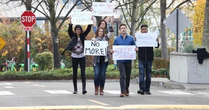 Group of protesters marching on the street with signs