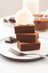 Chocolate brownies with salted caramel, vanilla ice cream. Copy space.