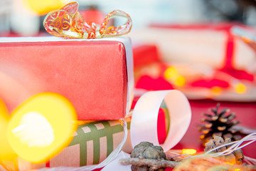 Female hands wrapping red christmas gift boxes