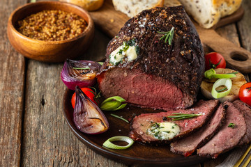 Roast beef on cutting board. Wooden background. Copy space.