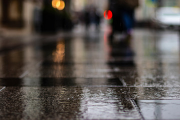 Wet rainy urban floor with blurry bokeh background