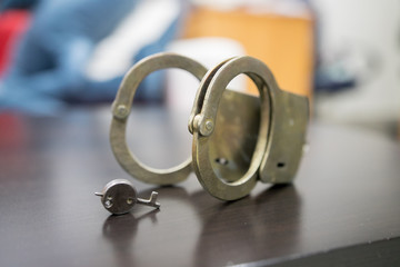 Law and order concept. Handcuffs isolated and copy space on a wooden background.
