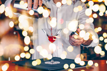 Barman pouring  cocktail at a nightclub. Nightlife and entertainment concept