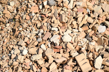 A pile of broken red brick with beige brick mixed in. Contrast texture, background