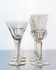 Decoration setup of wine and martini glasses set on a reflective table top.