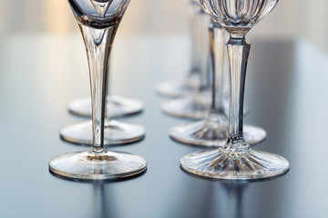 Decorative wine and martini glasses are set up in rows displaying  beautiful details of the base of...