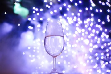 Happy New Year. One glass of champagne with fireworks lights.