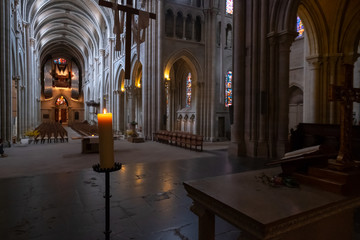 Fototapeta premium Interior of catholic cathedral, candle at foreground