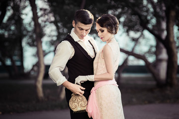 a girl and a young man together, communicate, laugh, a couple of lovers in costumes 30s, vintage photo