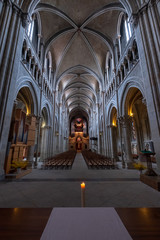 Fototapeta premium Interior of catholic cathedral, candle at foreground