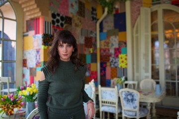 young beautiful woman pose on chair by window 
