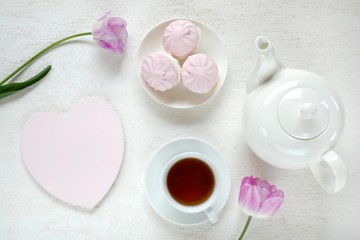 Valentine's Day. Breakfast in a romantic style. Tea, pink marshmallow, pink heart-shaped plate, pink tulip 