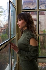Fototapeta premium young beautiful woman pose on chair by window 