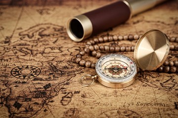 Vintage compass and spyglass telescope  on old map  - Explorer  concept