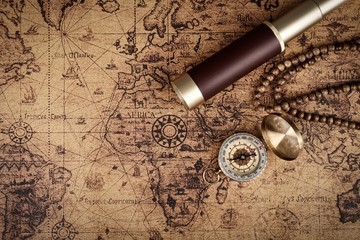 Vintage compass and spyglass telescope  on old map  - Explorer  concept