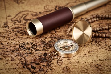Vintage compass and spyglass telescope  on old map  - Explorer  concept