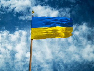 Ukraine flag Silk waving flag of Ukraine made transparent fabric with wooden flagpole gold spear on background sunny blue sky white smoke clouds real retro photo Countries of world 3d illustration