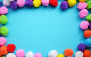 Multicolored POMpoms,  on a bright blue background for childrens creativity, needlework with a place under the text and a mocap.