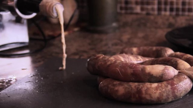 How to make sausage links with meat grinder. Woman use kitchenaid electric meat grinder. keto diet sausages from minced mince and pieces of meat in a natural casing