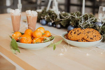 Oranges, cookies and cocoa with marshmallows on the Christmas table