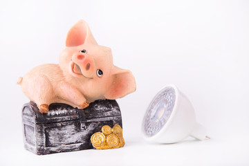 Led lamp and piggy bank lie on a white background