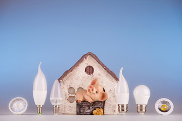 Led lamps and piggy bank standing on a blue background