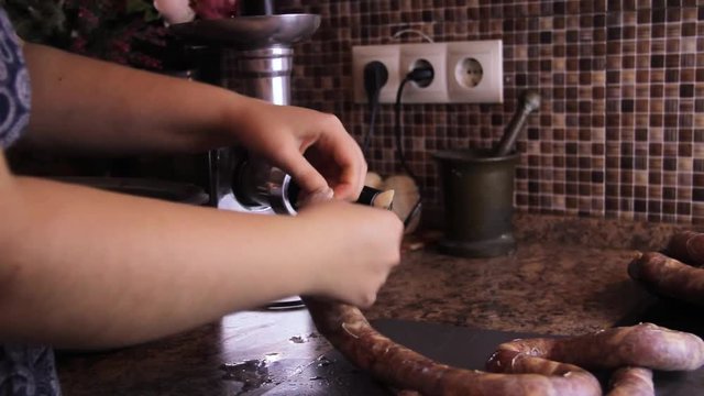 How to make sausage links with meat grinder. Woman use kitchenaid electric meat grinder. keto diet sausages from minced mince and pieces of meat in a natural casing