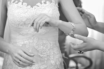 The bride prepares for the wedding ceremony. Wedding dress close-up. Bride's hands on the background of the dress.